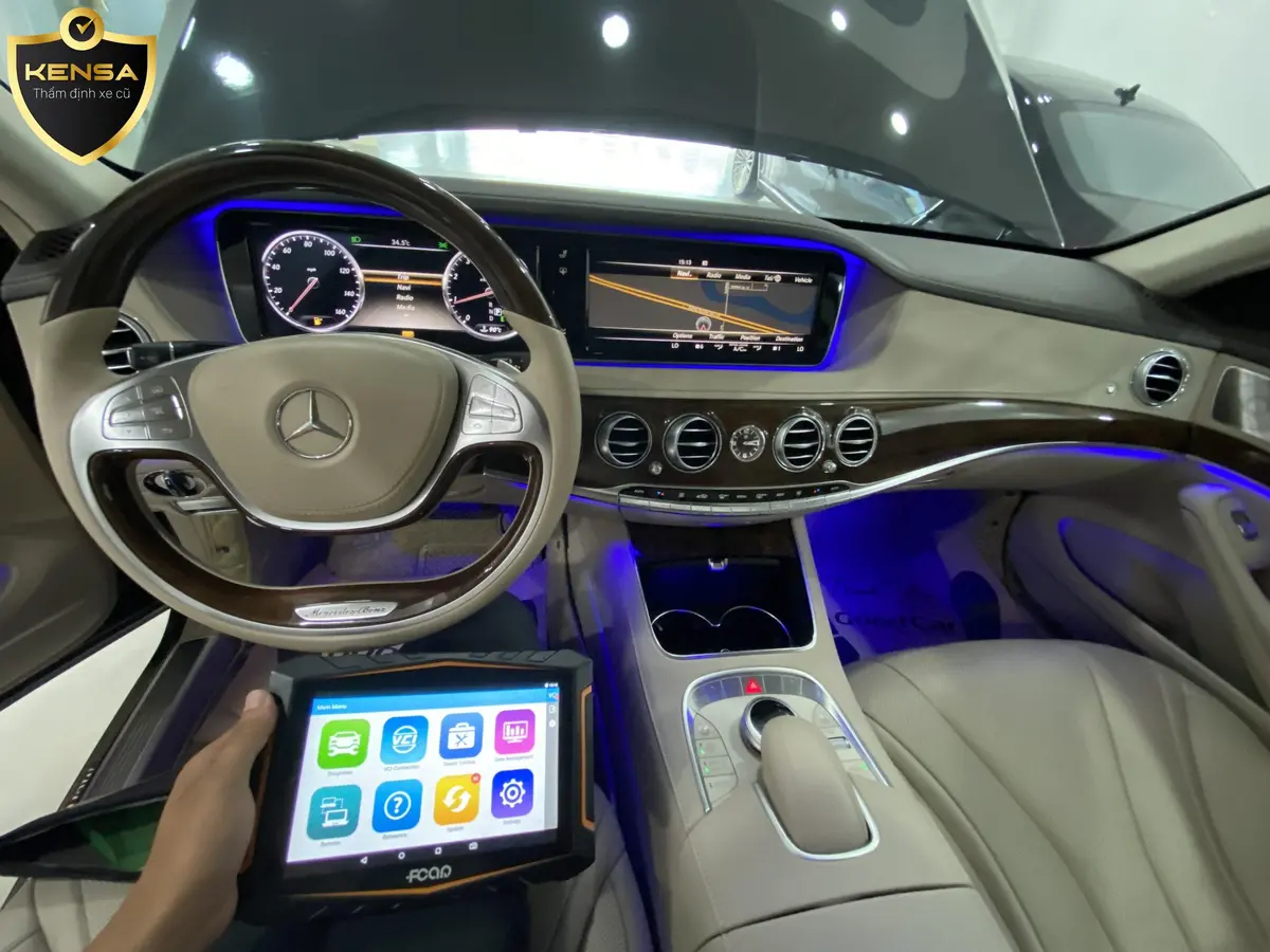 Hình ảnh chuyên gia đang kiểm tra động cơ và nội thất của một chiếc Mercedes S300 cũ.