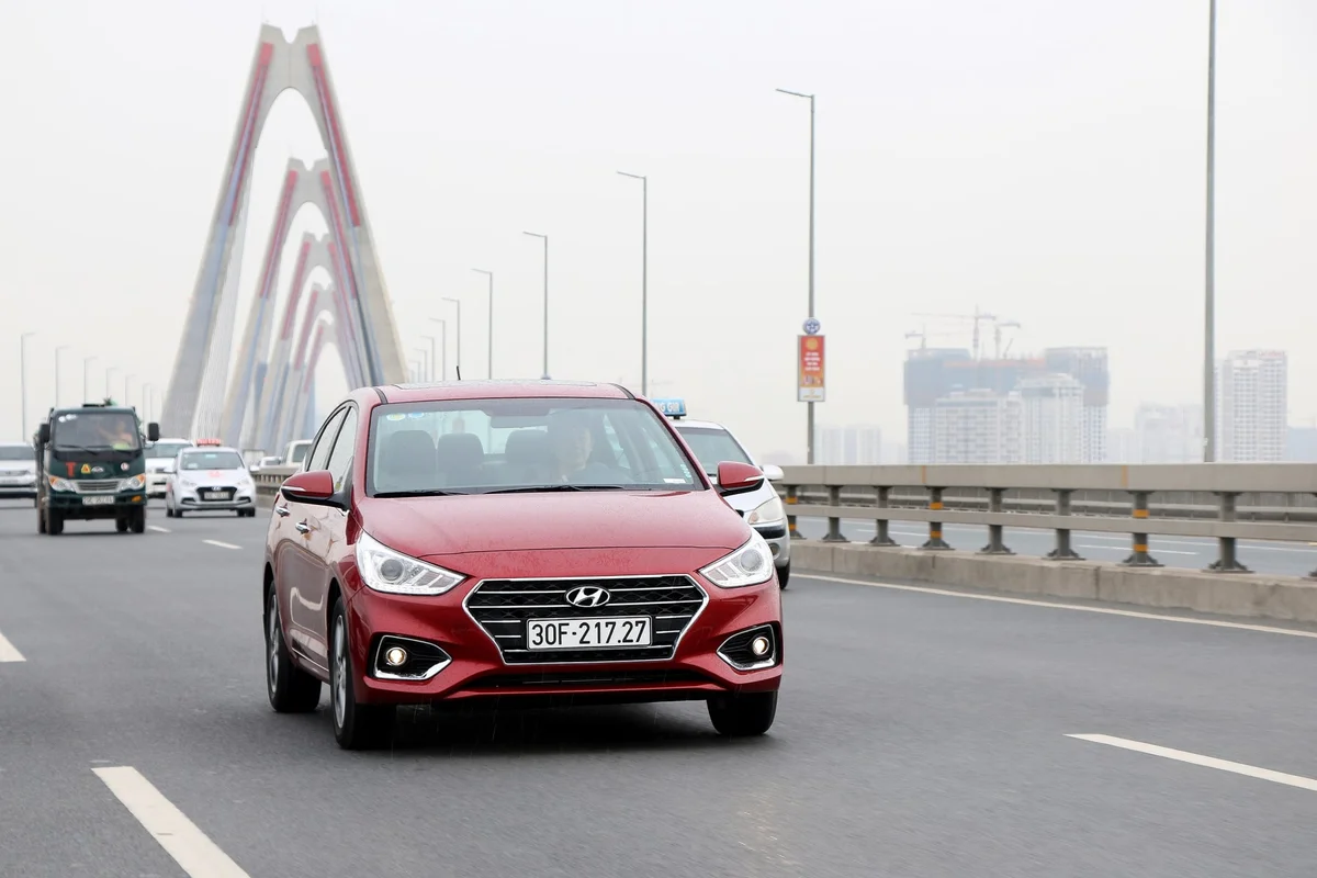 Hình ảnh xe Hyundai Accent 2019 màu trắng trên đường phố Việt Nam, minh họa sức ảnh hưởng của mẫu xe này trên thị trường.