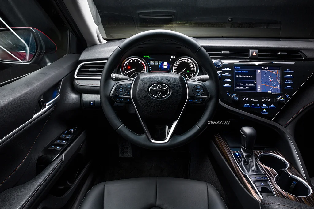 Hình ảnh nội thất của xe Toyota Camry 2.5 2019, hiển thị ghế da, màn hình trung tâm và các nút điều khiển, thể hiện sự tiện nghi và rộng rãi.