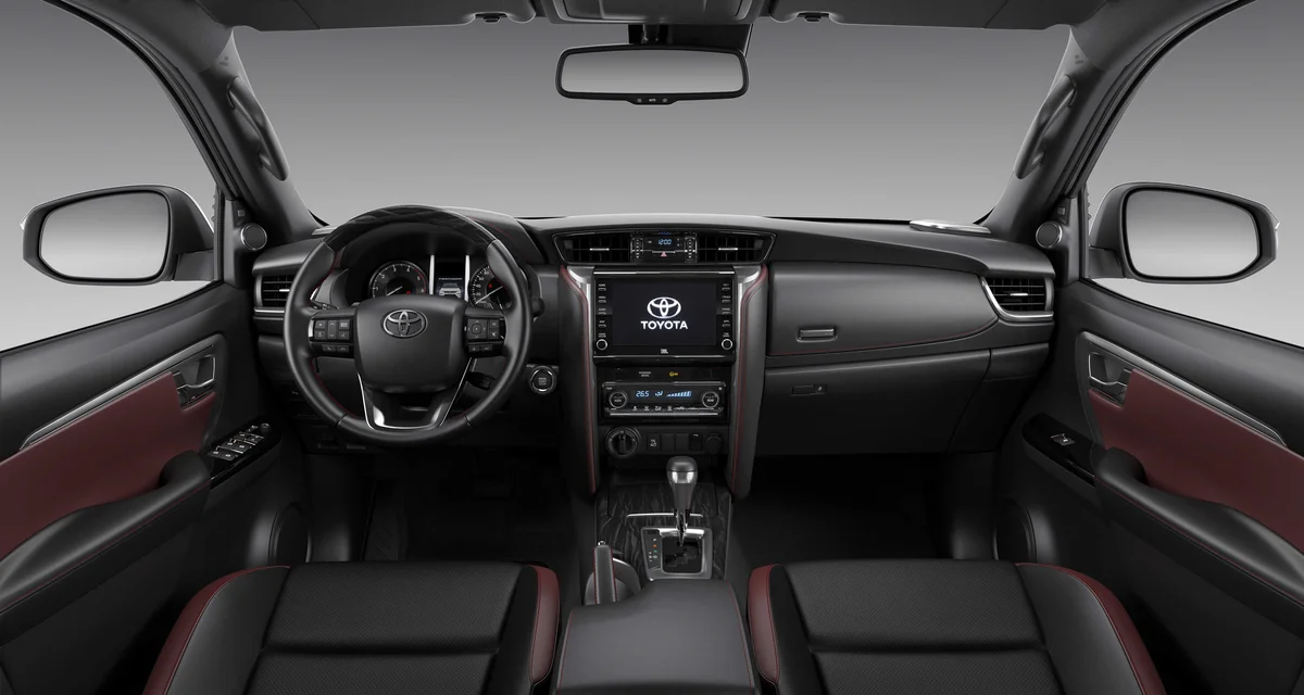 Hình ảnh nội thất Toyota Fortuner Legender với màn hình giải trí và các nút điều khiển, cùng logo Toyota Safety Sense