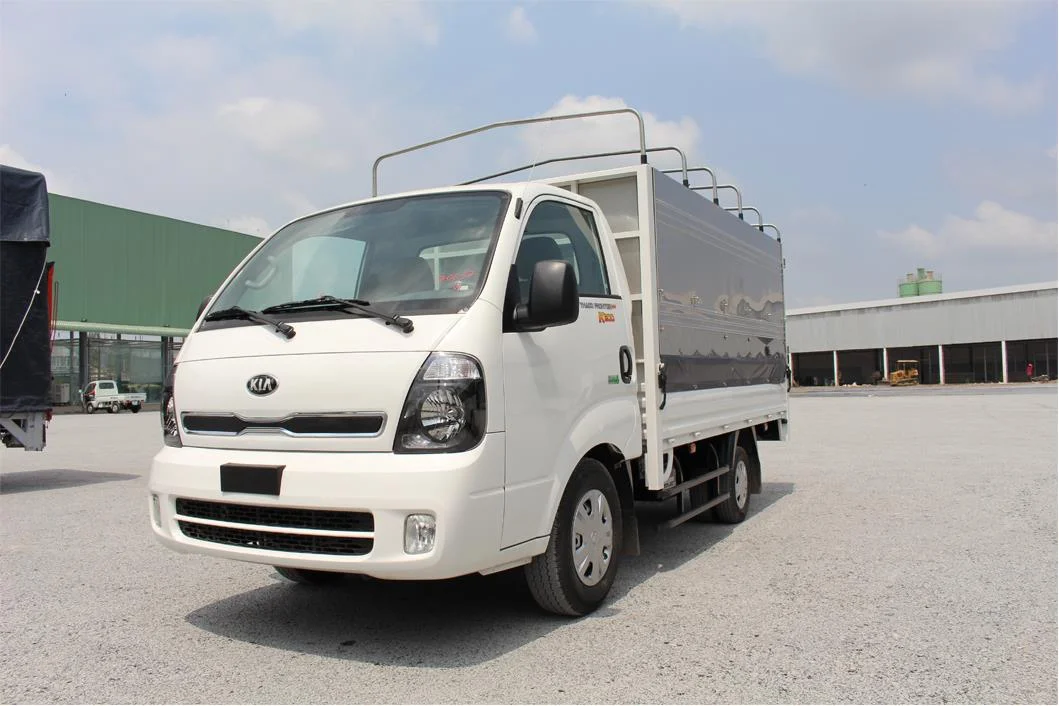 Hình ảnh một chiếc xe tải Kia K200 cũ màu trắng đang chở hàng trên đường, thể hiện khả năng vận hành và ứng dụng thực tế.