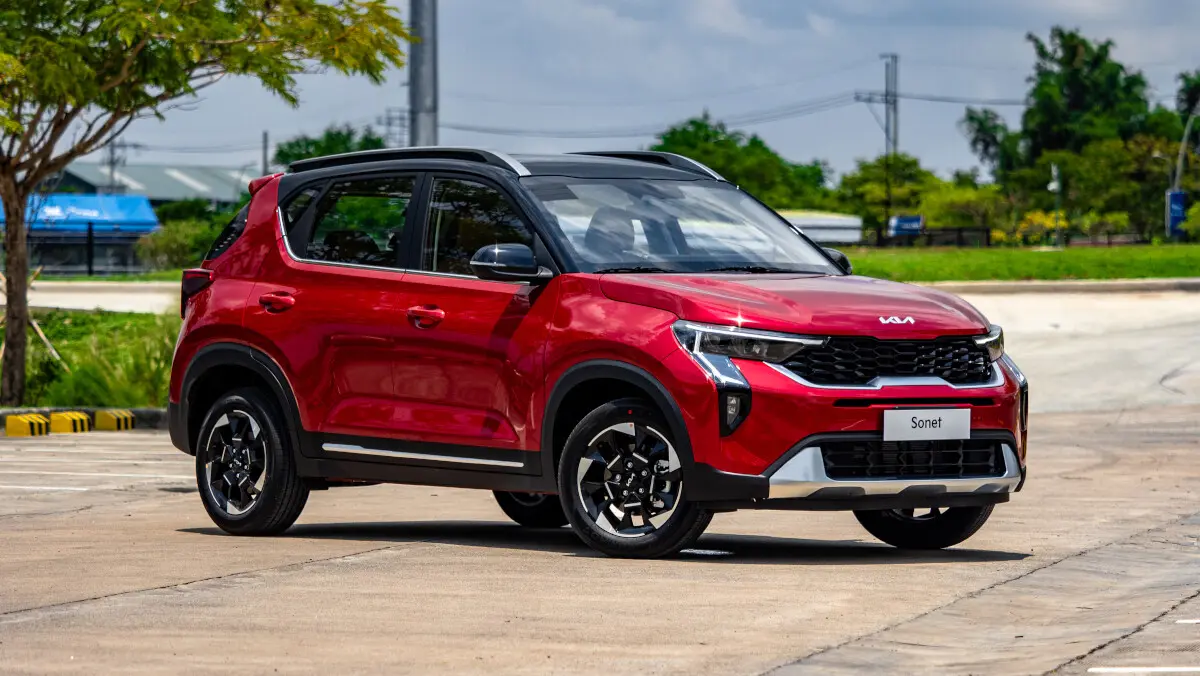 Hình ảnh Kia Sonet 2024 đang di chuyển trên đường hoặc đỗ trước một bối cảnh đô thị, thể hiện tính đa dụng.