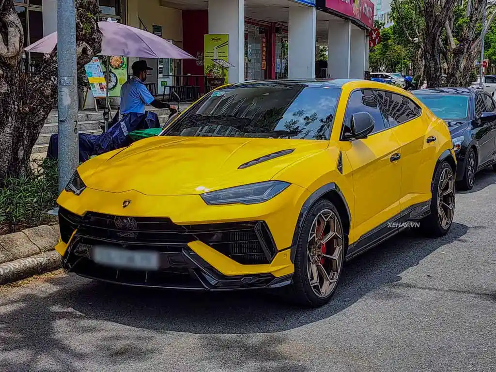 Lamborghini Urus màu xanh ngọc đi trên đường đô thị, thu hút mọi ánh nhìn.