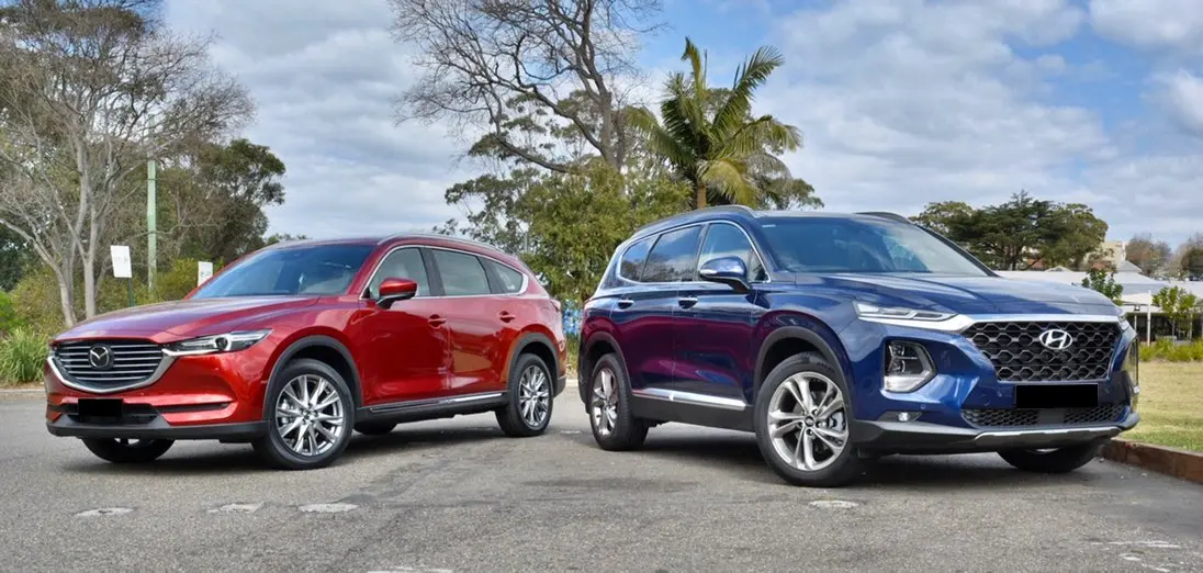 Hình ảnh so sánh Mazda CX-8 2019 và Hyundai Santa Fe 2019, hai mẫu SUV 7 chỗ phổ biến.