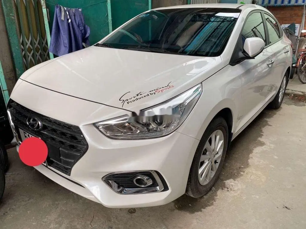 Hình ảnh cận cảnh một kỹ thuật viên đang kiểm tra khoang động cơ của xe Hyundai Accent 2019 cũ, minh họa các bước kiểm tra quan trọng.