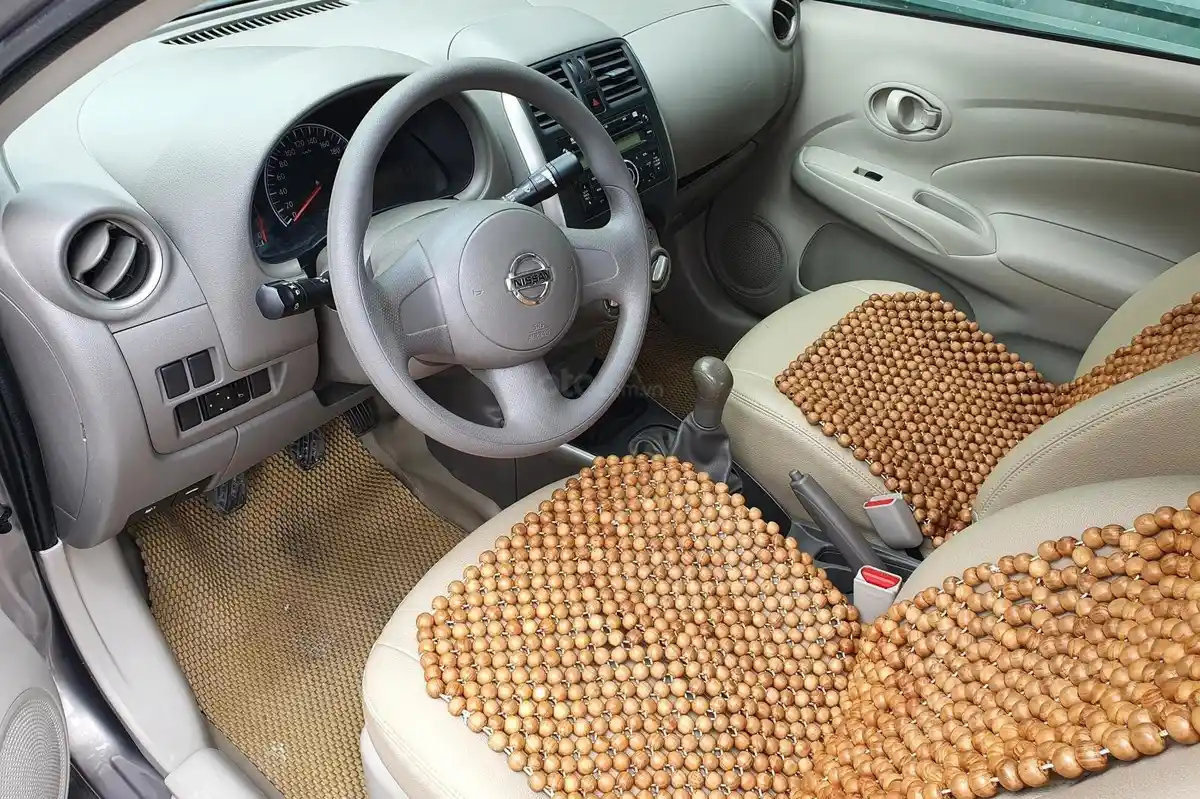 Hình ảnh nội thất Nissan Sunny cũ, với bảng điều khiển trung tâm cơ bản, vô lăng không có nút bấm điều khiển, và màn hình giải trí đơn giản.
