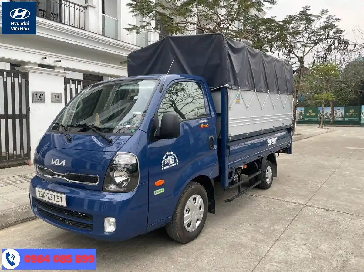 Một chiếc xe tải Kia K200 cũ với thùng mui bạt đang đỗ trên đường, minh họa xe tải đã qua sử dụng.