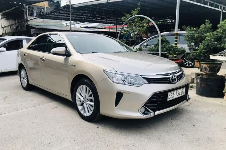 Hình ảnh xe Toyota Camry 2.0E màu trắng di chuyển trên đường, thể hiện ngôn ngữ thiết kế Keen Look năng động.
