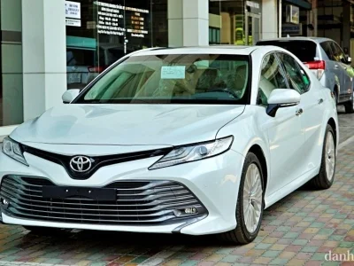 Hình ảnh xe Toyota Camry 2.5 2019 màu trắng hoặc đen, ngoại thất lịch lãm, di chuyển trên đường, thể hiện sự bền bỉ và giữ giá.