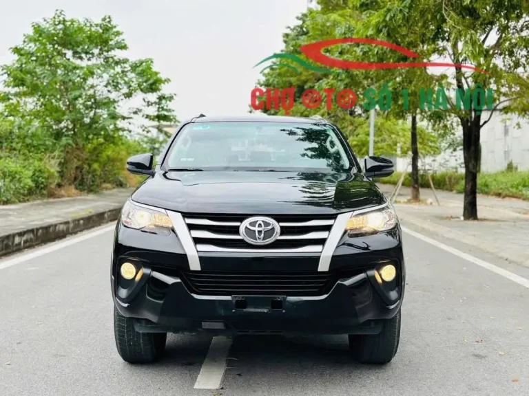 Xe Toyota Fortuner cũ màu trắng đang di chuyển trên đường, thể hiện sự bền bỉ
